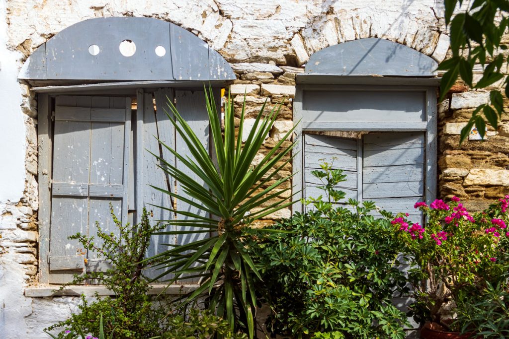 Fenster mit Blumen im Bergdorf Pirgos auf der griechischen Kykladeninsel Tinos