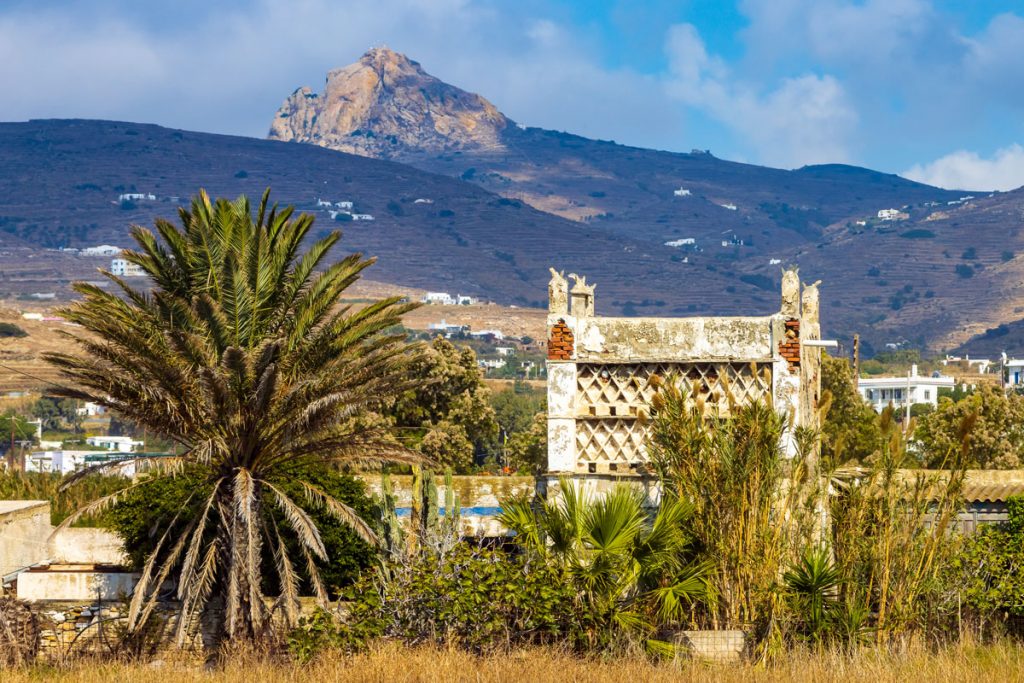 Traditioneller venezianischer Taubenturm bei Tinos-Stadt mit Gebirge im Hintergrund auf der griechischen Kykladeninsel