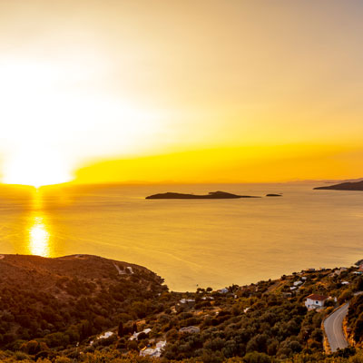 Sonnenuntergang über der Bucht des Ferienorts Batsi auf der griechischen Kykladeninsel Andros im Panorama
